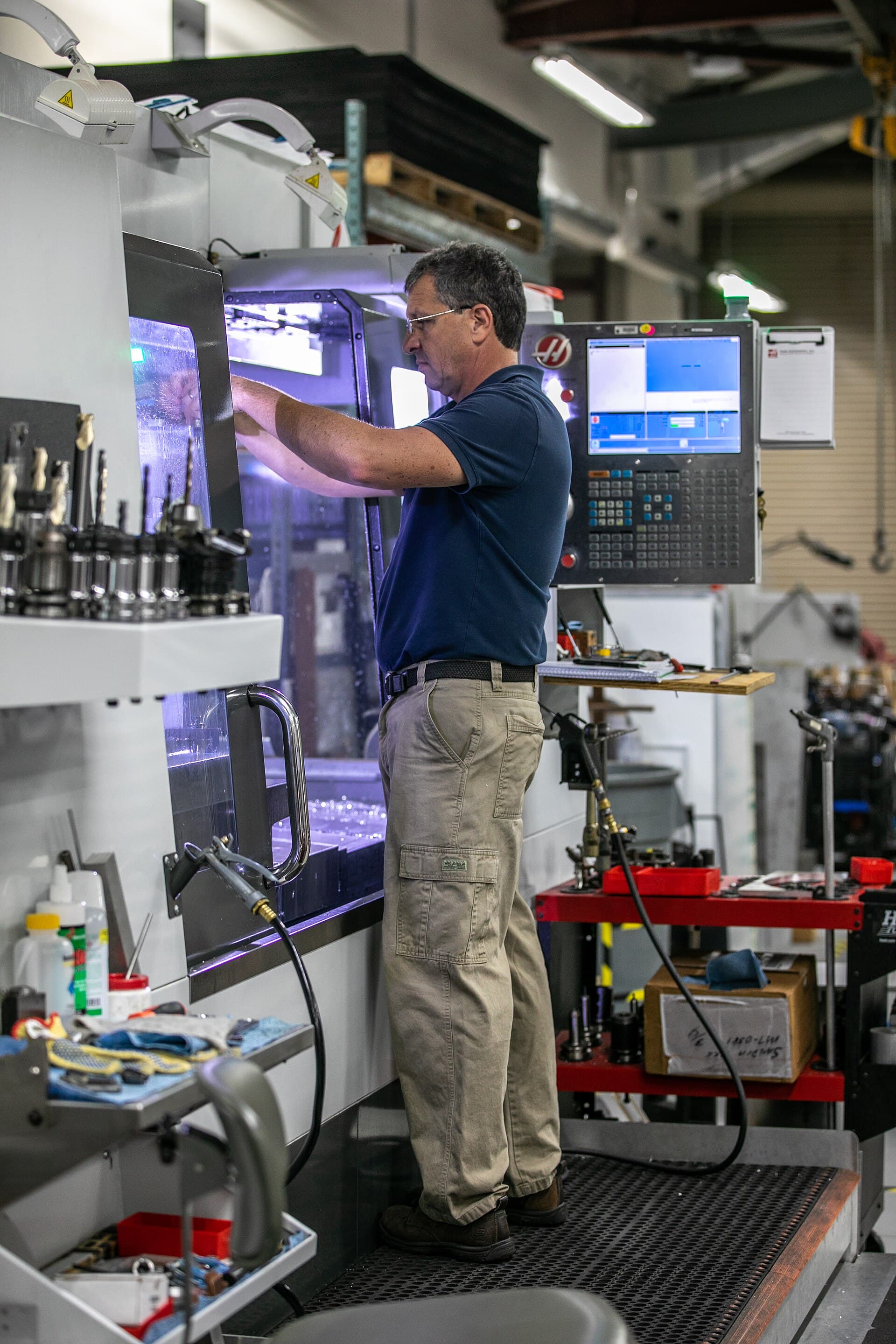 Engineering technician working at a CNC machine in a prototype development laboratory